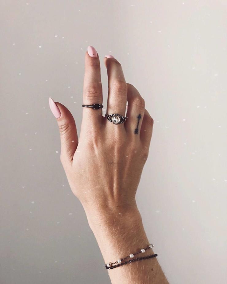 Tattoo with an arrow on the ring finger