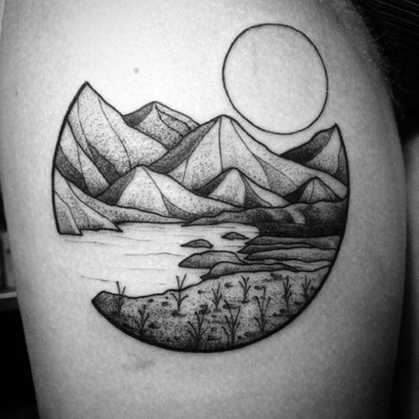 A tattoo depicting a lake and a mountain in the sun.