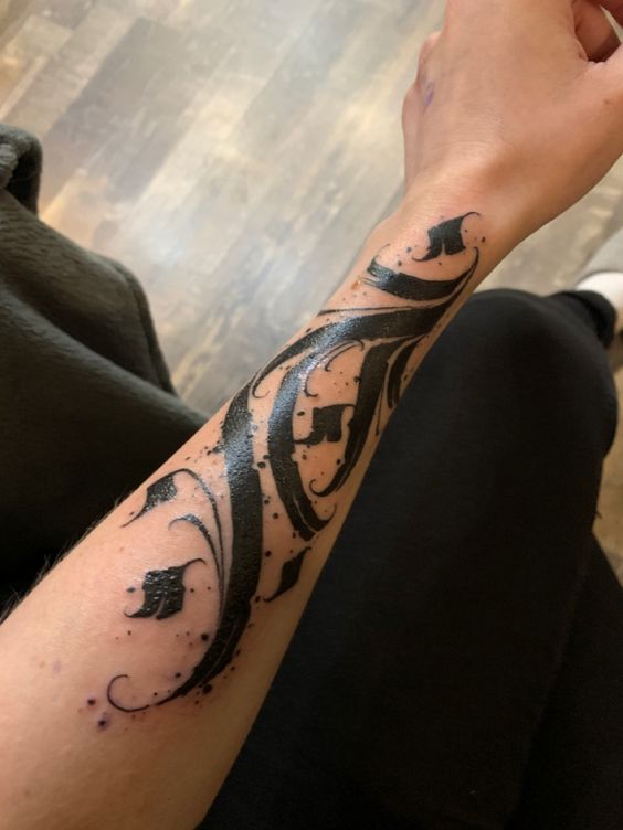 Calligraphy style tattoo on forearm