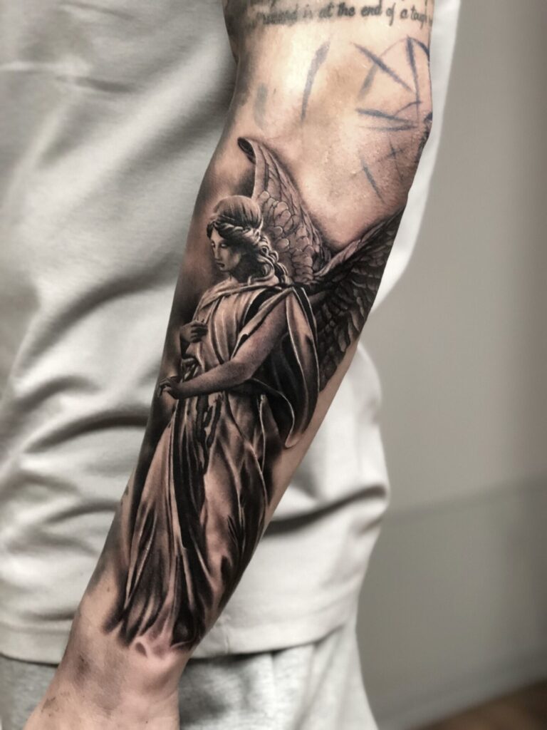 Realistic angel tattoo on the forearm