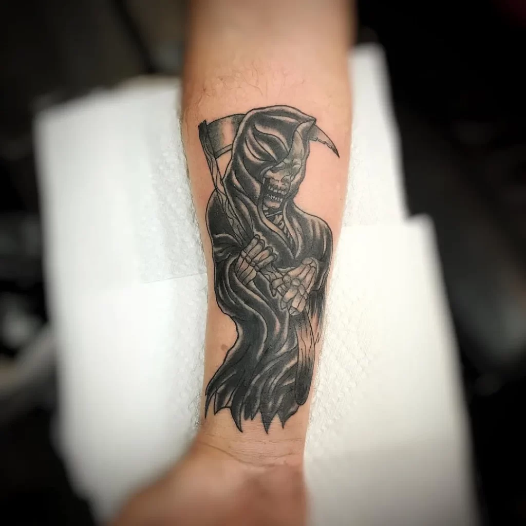 Death tattoo on forearm with a scythe