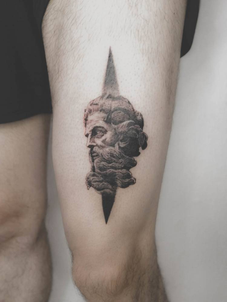 A small tattoo of the god Poseidon on his leg