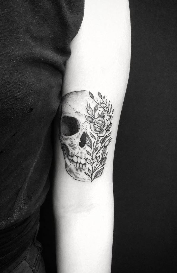 Tattoo of a skull with flowers on the arm