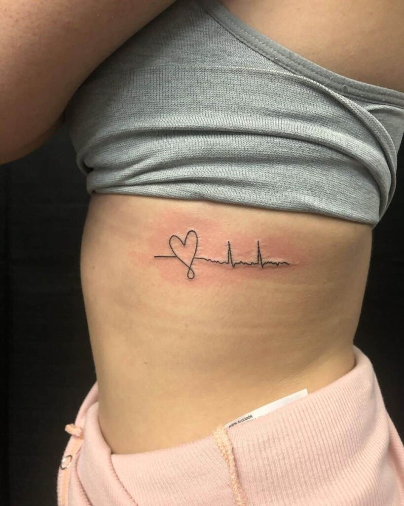 Tattoo of a small heart on the side under the chest