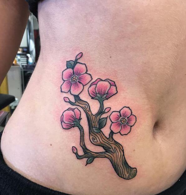 Tattoo of a sakura flower on the stomach for women