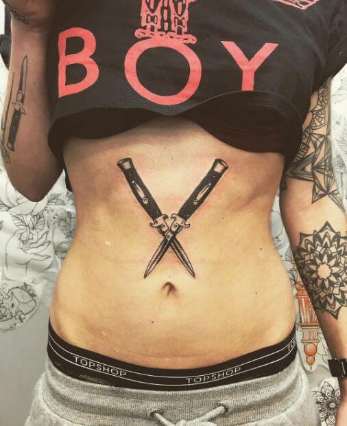 Tattoo of a dagger on his stomach