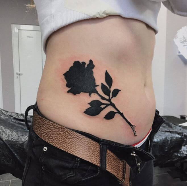 Black rose tattoo on stomach