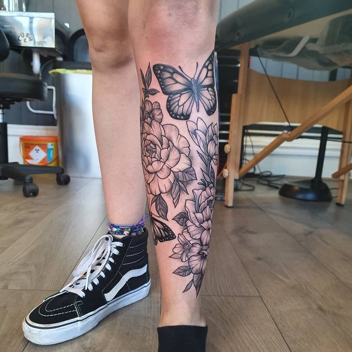 Flower and butterfly tattoo on the shin