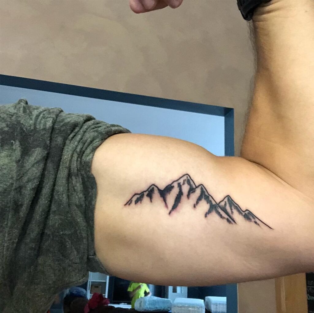 Tattoo of a mountain on the biceps