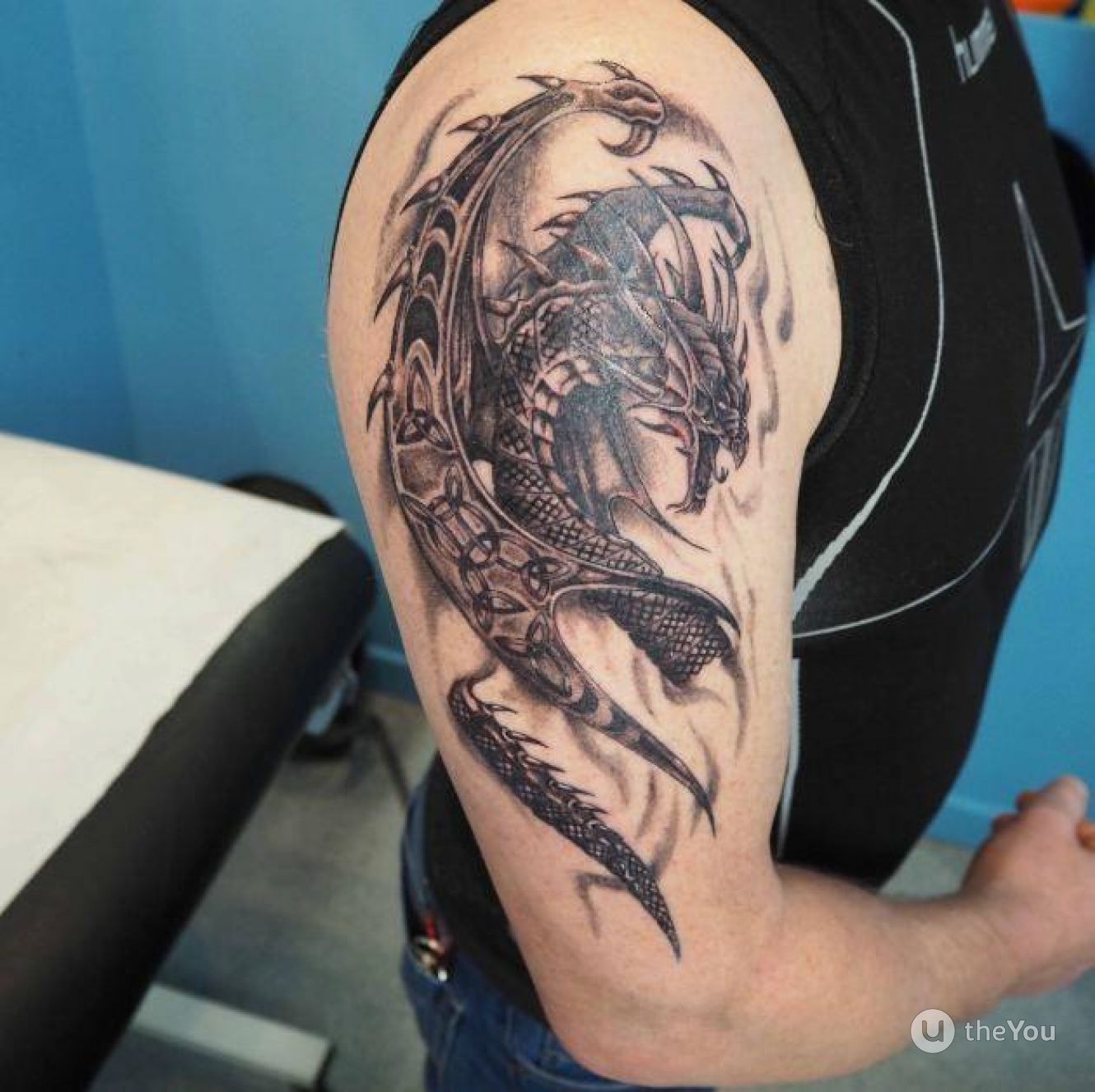 Tattoo of a dragon on the shoulder in fantasy style