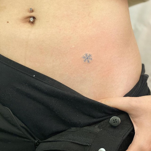 Small snowflake tattoo on the hip