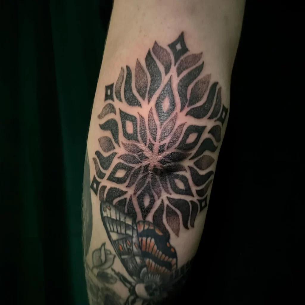 Retro tattoo on the elbow with black ink