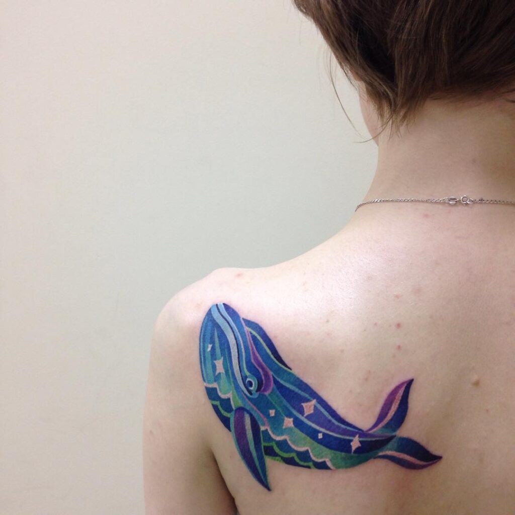 Tattoo of a whale on the scapula