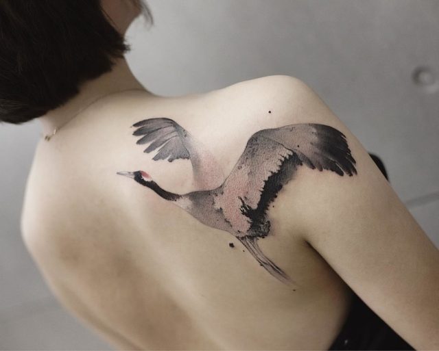 Tattoo of a crane on the shoulder blade