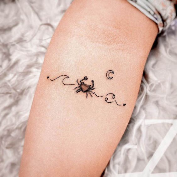 Tattoo of the zodiac sign Cancer on the forearm for women