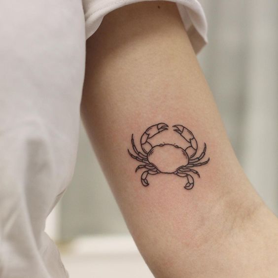 Tattoo of the zodiac sign of Cancer on the shoulder for women