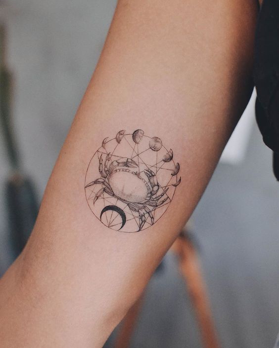 Tattoo of the zodiac sign of Cancer on the shoulder for women