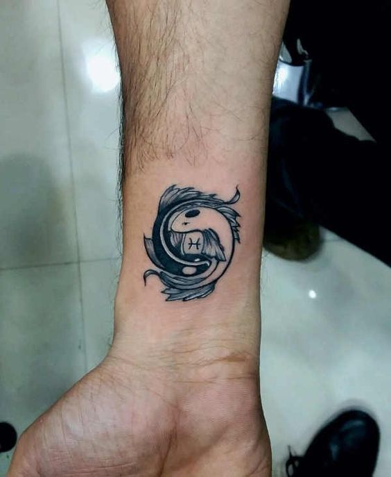 Tattoo of the zodiac sign of a fish on the wrist for men