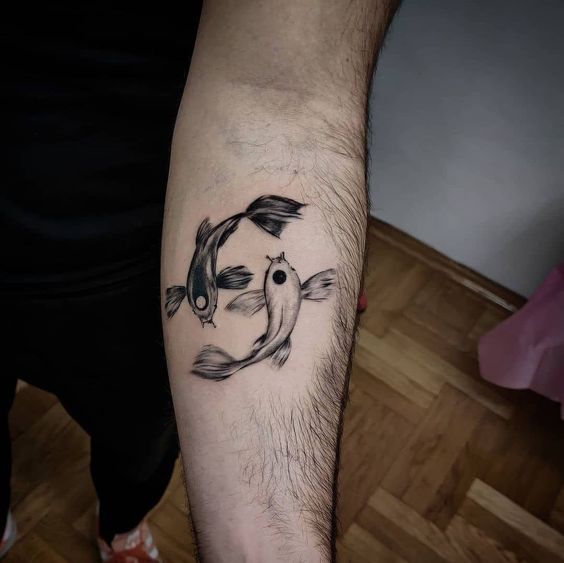 Tattoo of the zodiac sign of a fish on the forearm for men