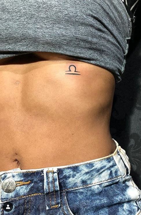 Tattoo symbol of the zodiac sign Libra on the stomach for women