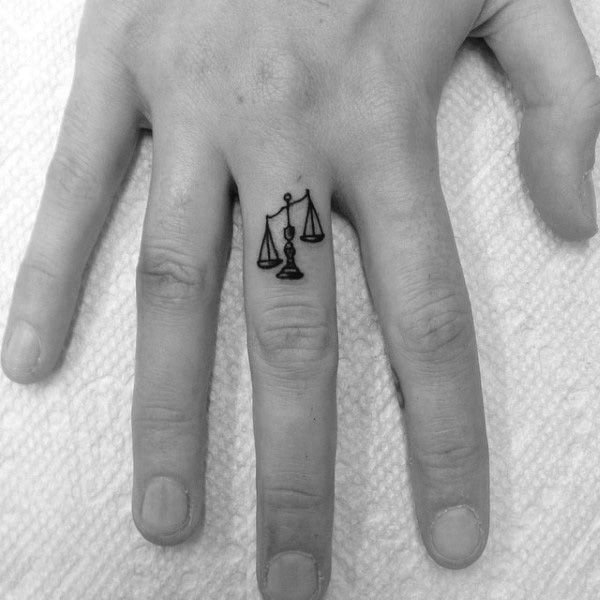 Tattoo of the zodiac sign Libra on the finger for men