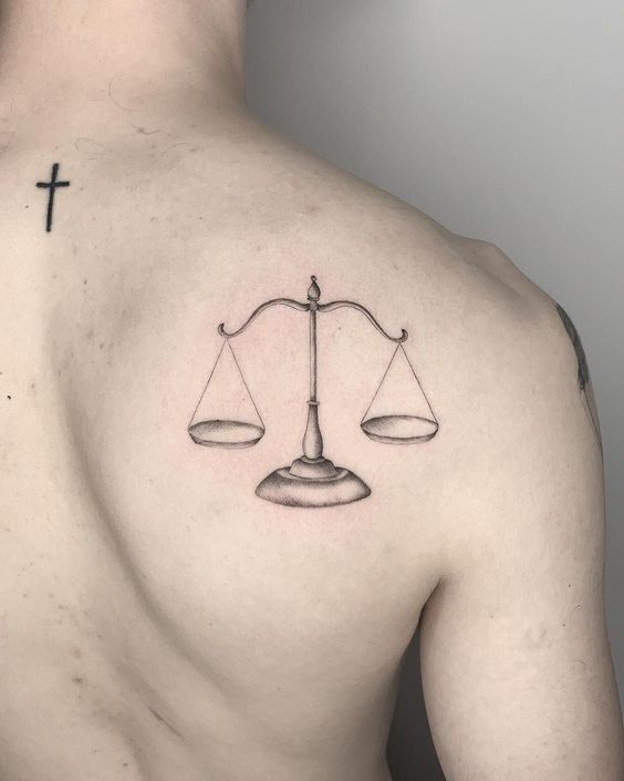 Tattoo of the zodiac sign Libra on the shoulder blade for men