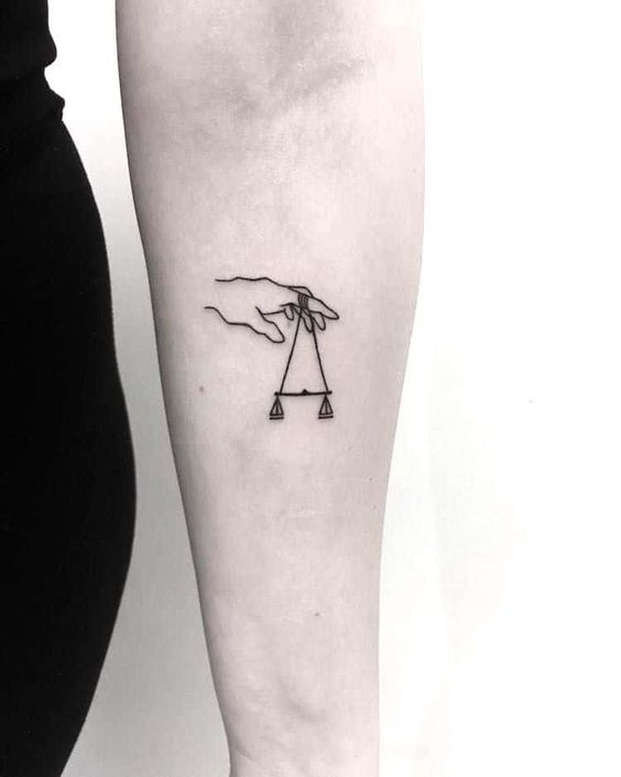 Tattoo of the zodiac sign Libra on the forearm for men