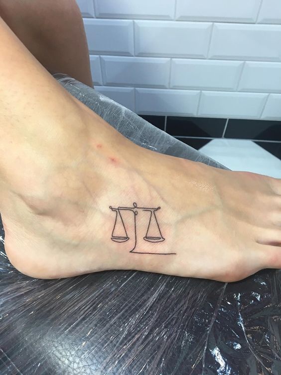 Tattoo of the zodiac sign Libra on the foot for women