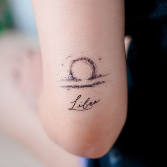 Tattoo symbol of the zodiac sign Libra on the shoulder for women