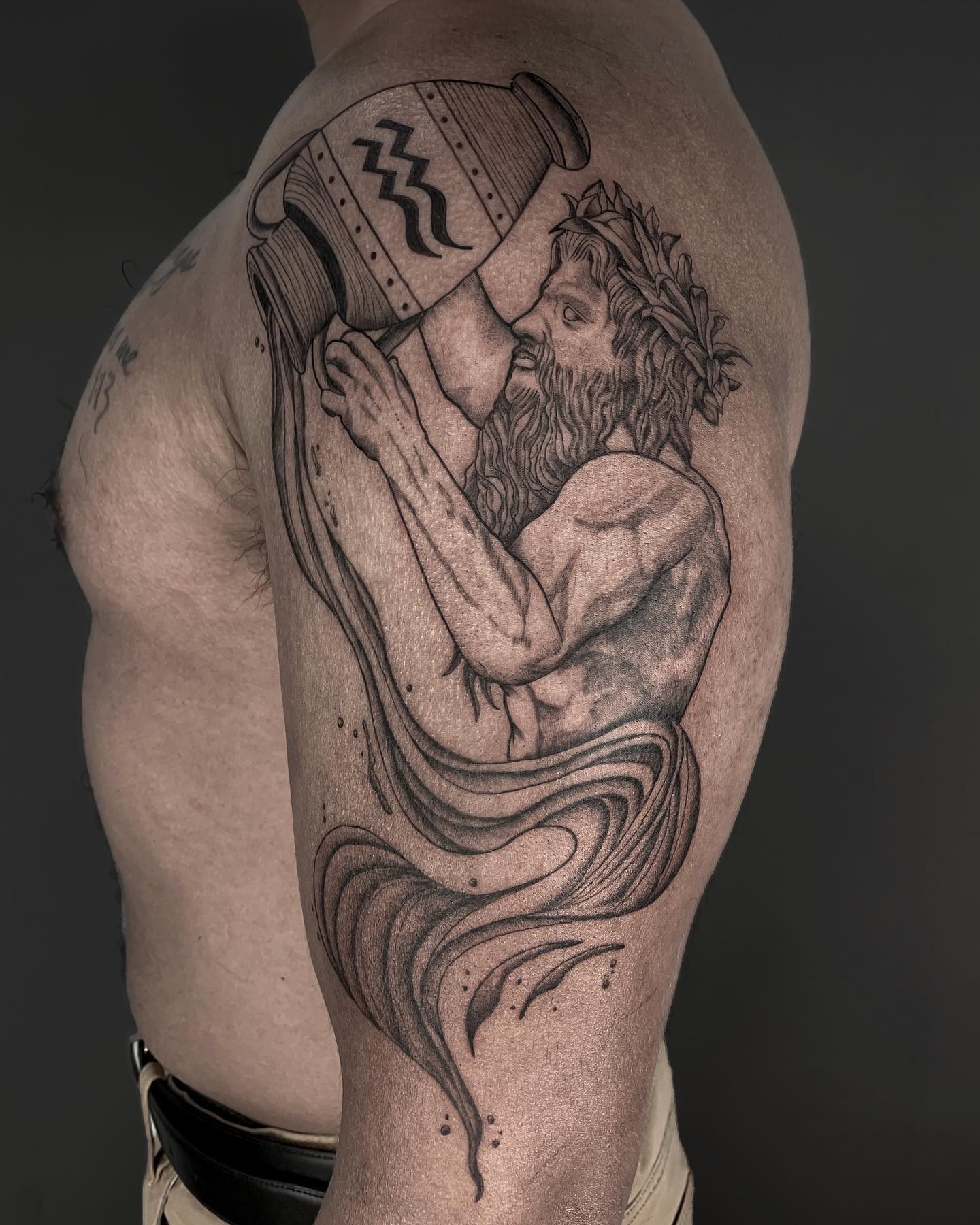 Aquarius zodiac sign tattoo on the shoulder for men