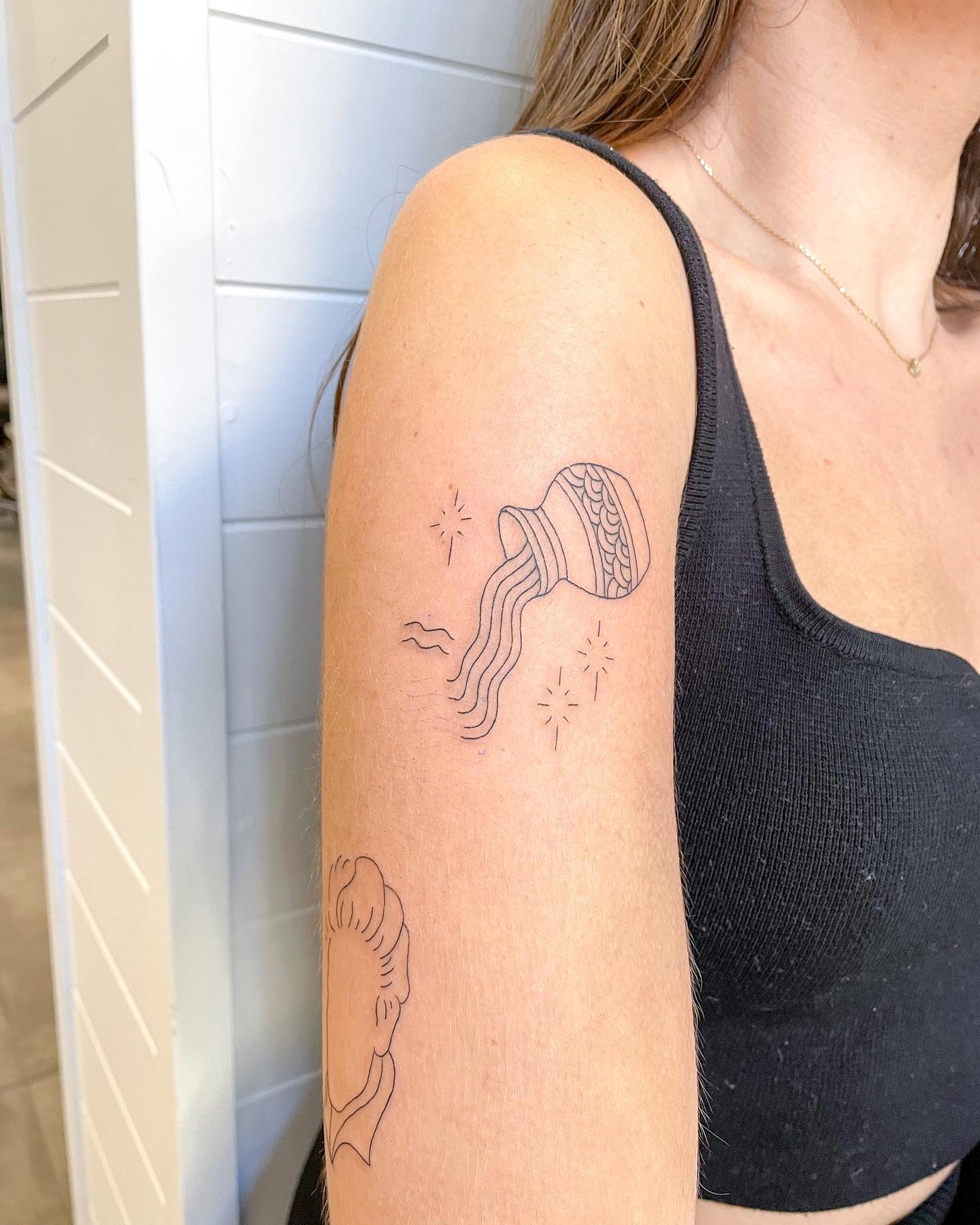 Aquarius zodiac sign tattoo on the shoulder for women