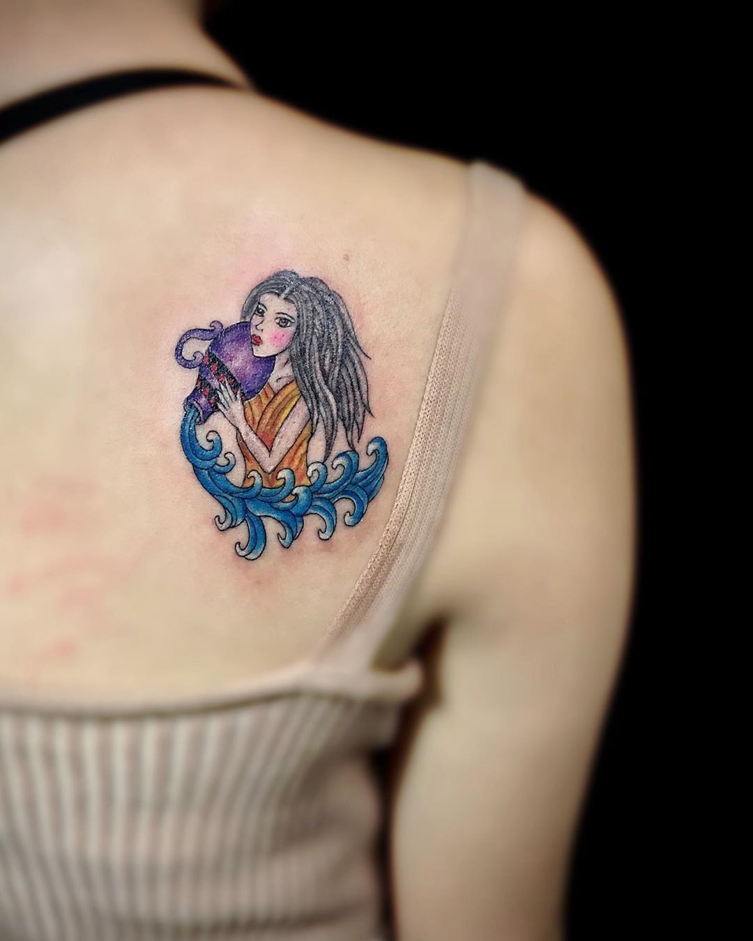 Aquarius zodiac sign tattoo on the shoulder for women