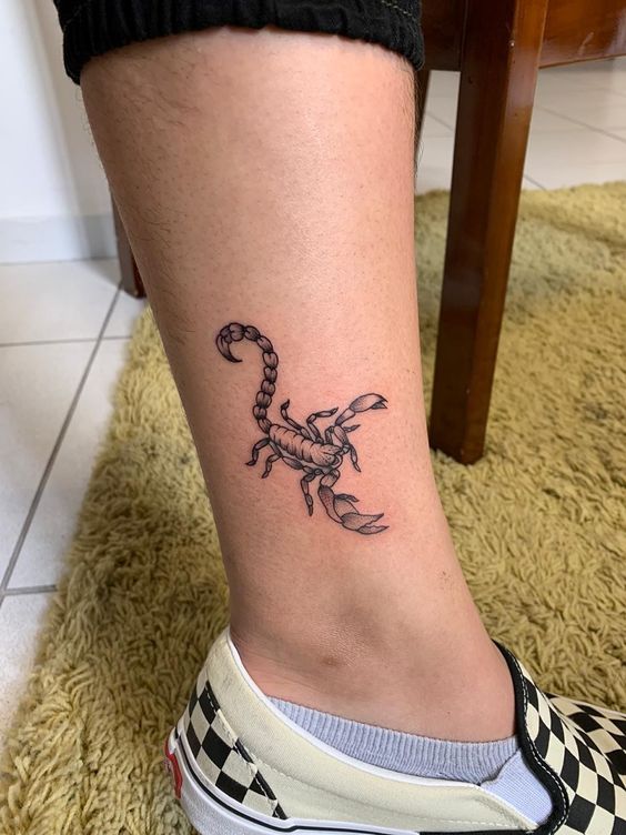 Tattoo of the zodiac sign of the scorpion on the shin for women