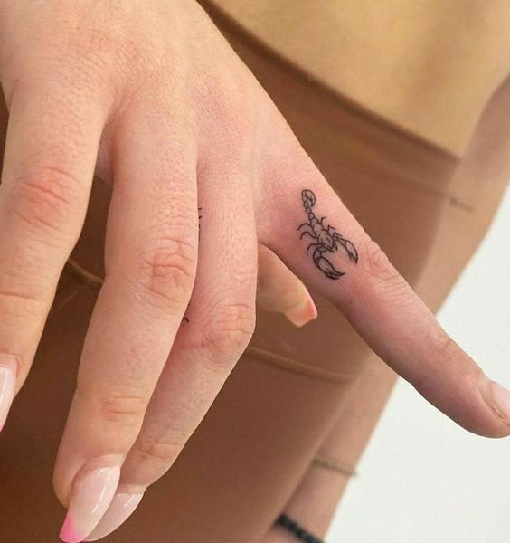 Tattoo of the zodiac sign of a scorpion on the finger for women