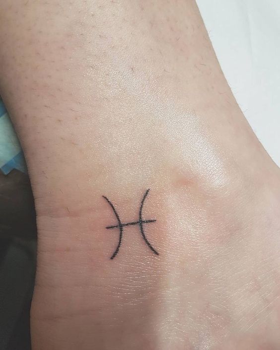 Tattoo of the zodiac sign fish symbol on the ankle for women