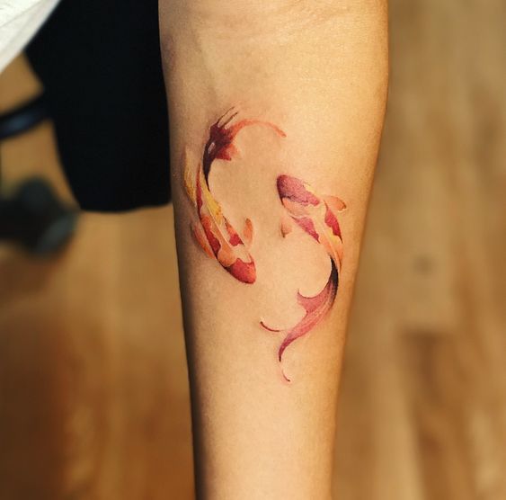 Tattoo of the fish zodiac sign on the forearm for women