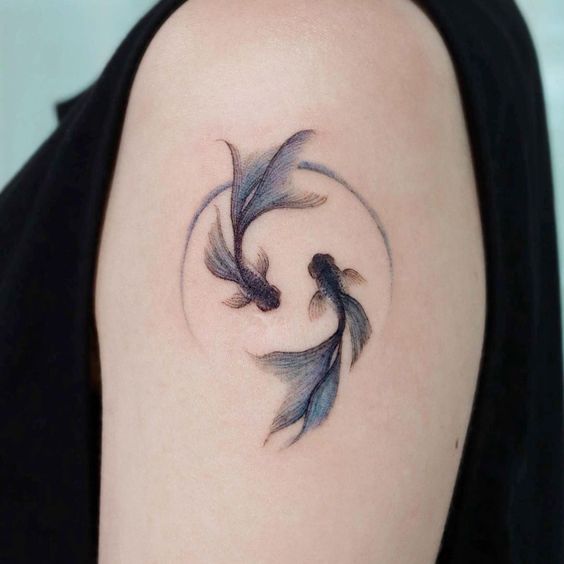 Tattoo of the zodiac sign of a fish on the shoulder for women