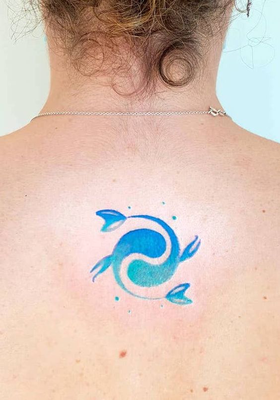 Tattoo of the fish zodiac sign on the back for women