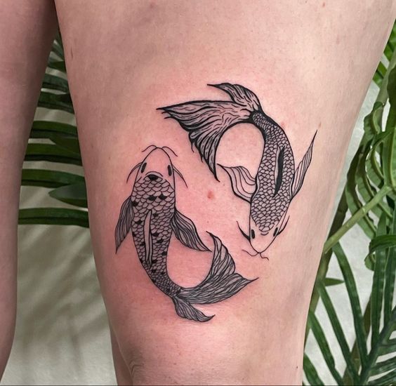 Tattoo of the fish zodiac sign on the thigh for women