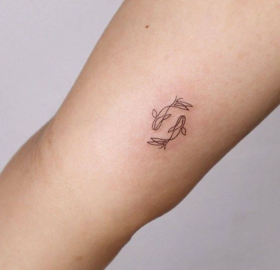 Tattoo of the zodiac sign of a fish on the shoulder for women