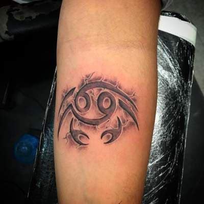 Tattoo of the zodiac sign of Cancer on the forearm for men