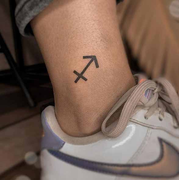 Tattoo symbol of the zodiac sign Sagittarius on the lower leg for women