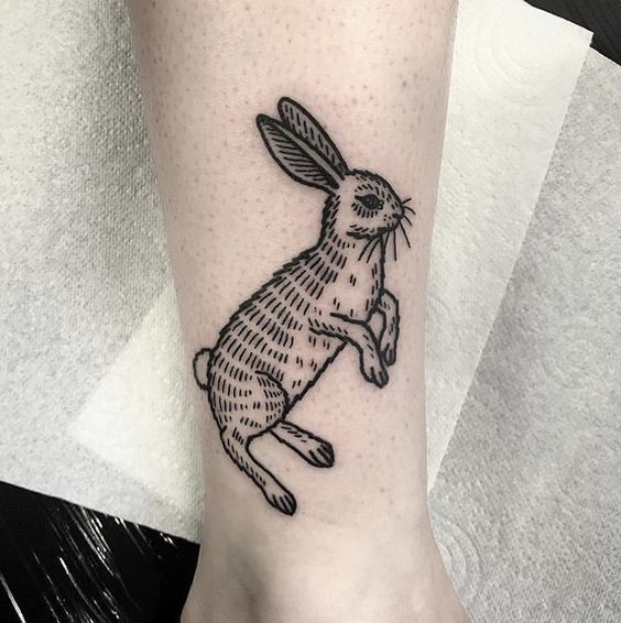 Tattoo of a hare (rabbit) on the leg for women