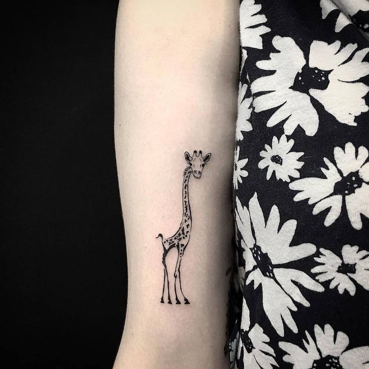 Tattoo of a giraffe on the forearm for women