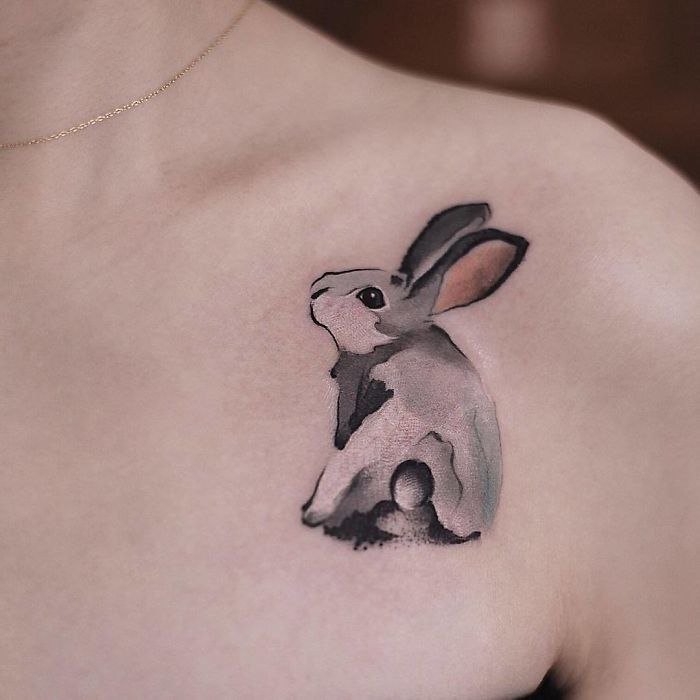 Tattoo of a hare (rabbit) on the collarbone for women