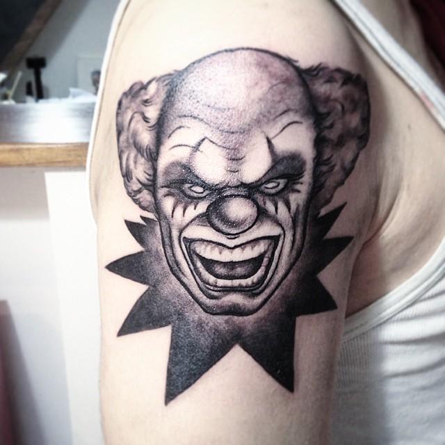 Tattoo of a clown on the shoulder for men