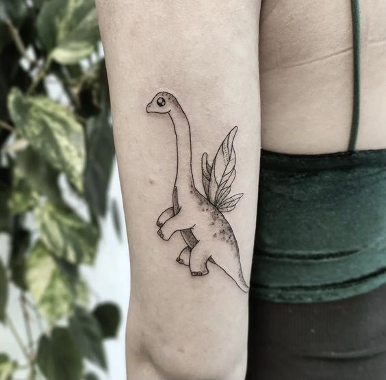 Tattoo of a dinosaur on the arm for women