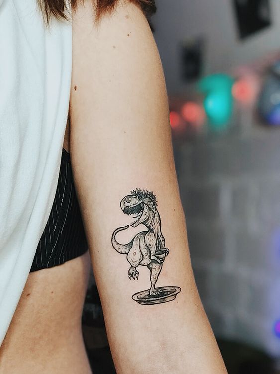 Dinosaur tattoo on the shoulder for women