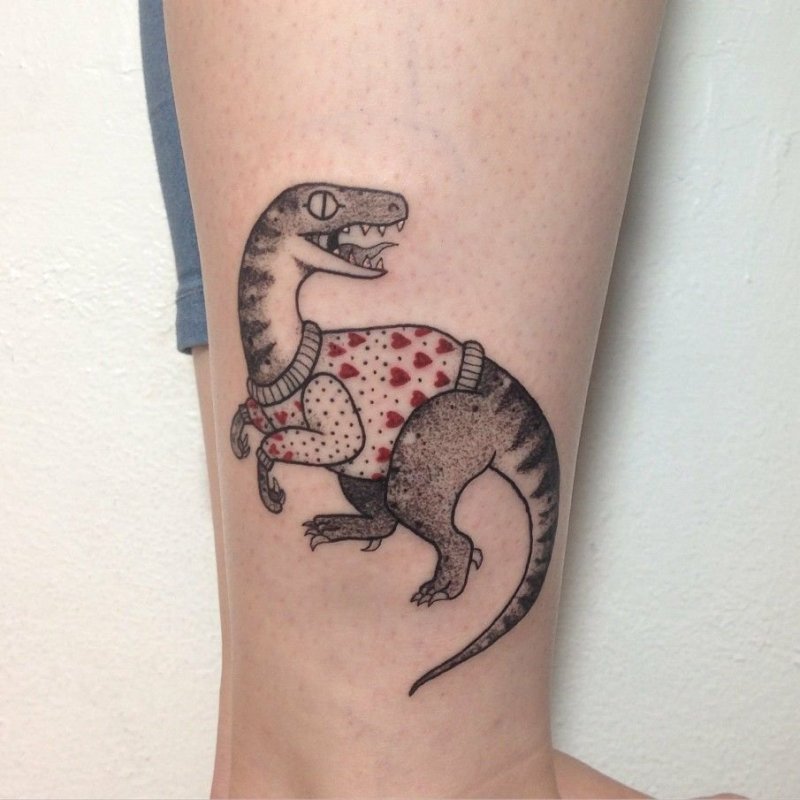 Tattoo of a dinosaur on the leg for women