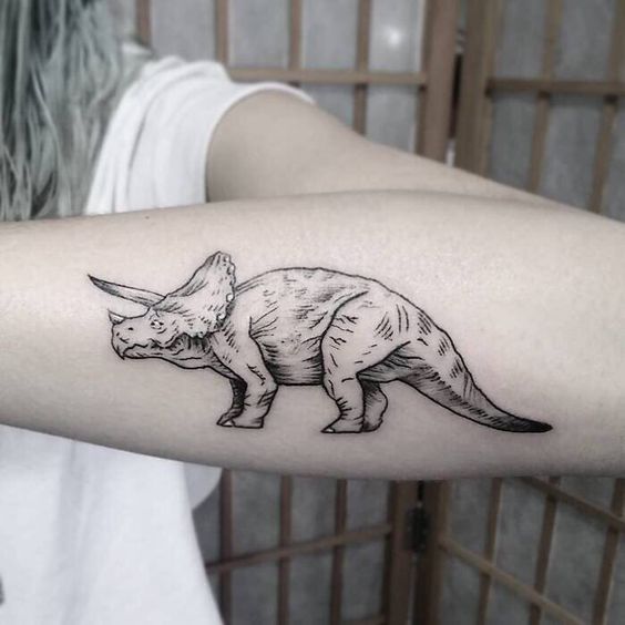 Tattoo of a dinosaur on the forearm for women